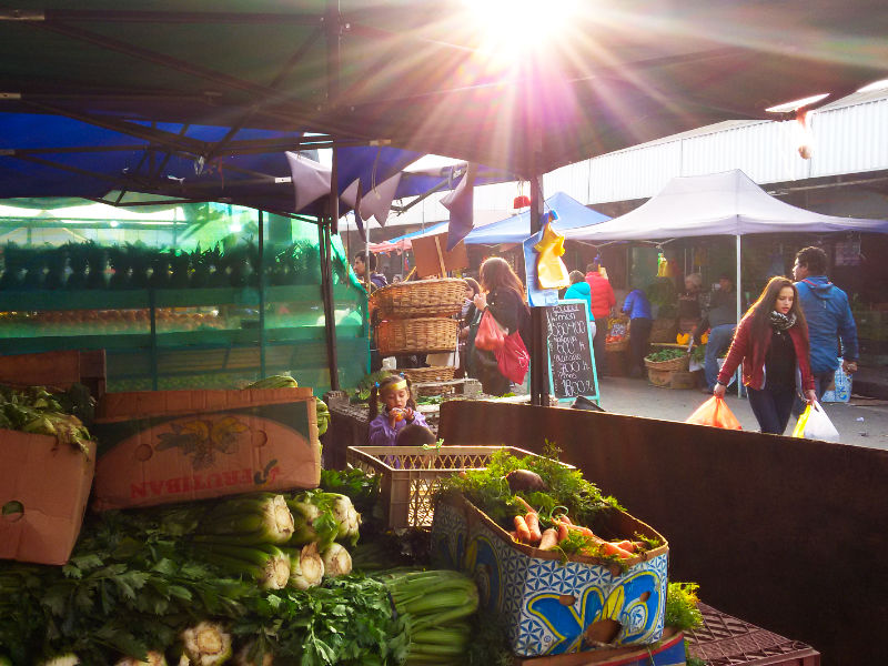 Local de verduras, niña y personas comprando en el Mercado de la Vega Central en Santiago - Foto de AHM